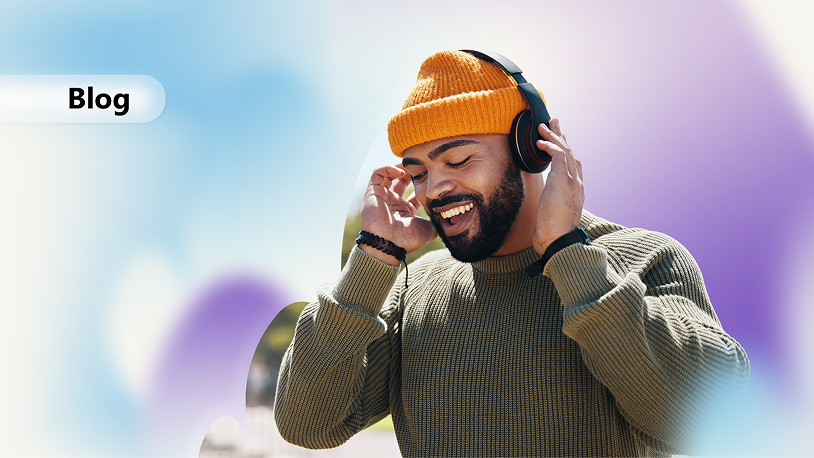 The image shows a person wearing a beige sweatshirt and orange knit cap, listening to music with headphones, and holding a phone.